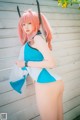 A woman with pink hair wearing a blue and white outfit.