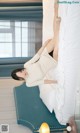 A woman laying on top of a bed next to a lamp.