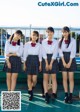 A group of young women in school uniforms posing for a picture.