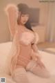 A woman in lingerie sitting on a bed.