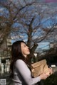 A woman holding a brown paper bag in her hands.