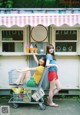 A couple of women standing next to each other in front of a store.