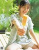 A woman sitting on a wooden bench holding a popsicle.