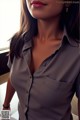 A woman in a gray shirt is posing for a picture.