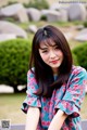 A woman in a floral dress posing for a picture.